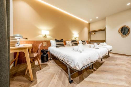 a row of beds in a room with a desk at Hostal Ambos Mundos in Barcelona