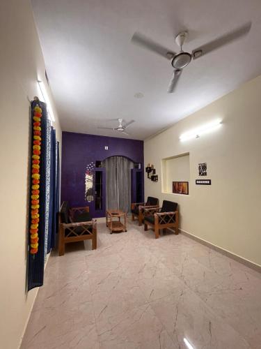 a living room with a couch and a ceiling fan at Maanyatha Homestay in Udupi