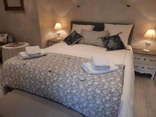 a bedroom with a large bed with two towels on it at Au Bonheur d'Angeline in Castelnaud La Chapelle