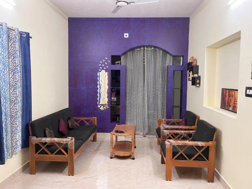 a living room with a couch and chairs in a room at Maanyatha Homestay in Udupi