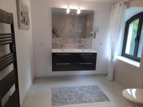 a bathroom with a sink and a mirror at Au Bonheur d'Angeline in Castelnaud La Chapelle