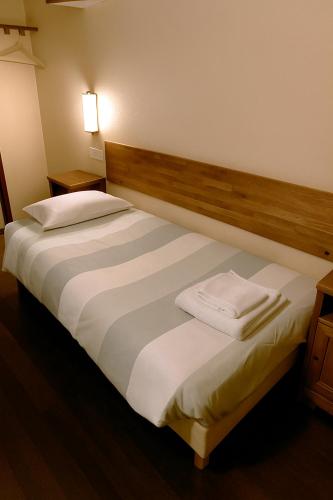 two beds in a hotel room with towels on them at Résidence Molière Hôtel Paris Montrouge in Montrouge