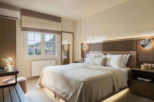 a hotel room with a large bed and a window at Meteoron Suites in Kalabaka
