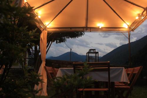 a table and chairs under a tent with a view at Agli Chalet Erbe Montane con parcheggio privato in Domodossola