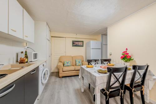 une cuisine et un salon avec une table et des chaises dans l'établissement Location meublé Ty Kim, à Le Folgoët