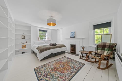 a white bedroom with a bed and a fireplace at Mackinnon Cottage - 3 bedroom Cottage in Broadford