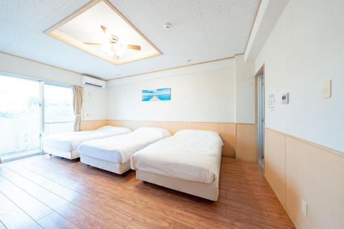 two beds in a room with a ceiling at unito villa OKINAWA Koza in Okinawa City