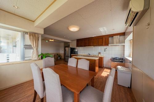 a kitchen and dining room with a wooden table and chairs at unito villa OKINAWA Koza in Okinawa City