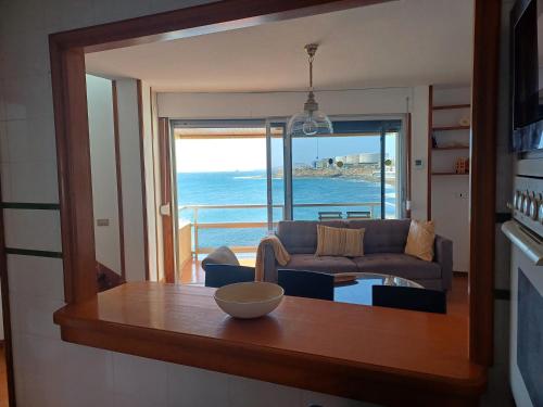 Una sala de estar con un sofá y vista al mar. en Salinetas VISTAMAR, en Telde
