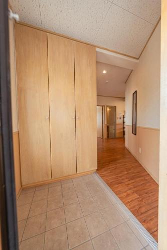 an empty room with wooden cabinets and a tile floor at unito villa OKINAWA Koza in Okinawa City