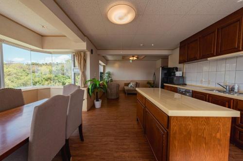 a kitchen with a table and chairs and a large window at unito villa OKINAWA Koza in Okinawa City