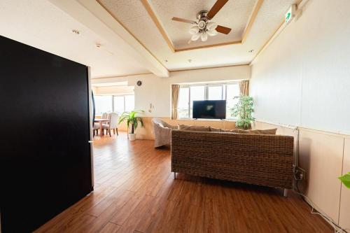 a living room with a ceiling fan and a couch at unito villa OKINAWA Koza in Okinawa City