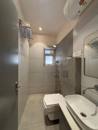 a bathroom with a white toilet and a sink at Hotel Metro Prime in Kolkata