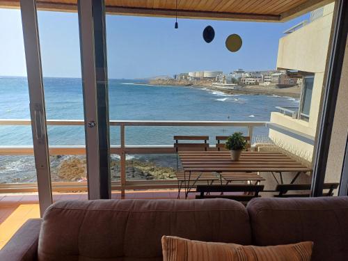 a living room with a couch and a view of the ocean at Sobre el Mar by CanariApartment, Oceanfront House with 3 Balconies in Salinetas in Telde