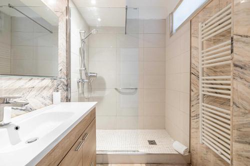 une salle de bain avec un lavabo blanc et une douche dans l'établissement Elegance and Refinement, proximity to La Croisette, à Cannes