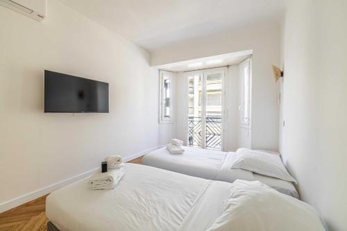 Cette chambre dispose de 2 lits et d'une télévision murale. dans l'établissement Elegance and Refinement, proximity to La Croisette, à Cannes