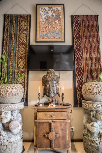 a room with a statue on a table with two vases at Avalon Ubud Castle & SPA in Ubud