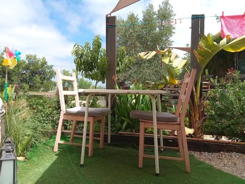 two chairs and a table in a garden at Glamping Algarve Retiro dos sonhos in Porches