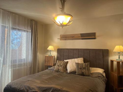 Un dormitorio con una cama con una lámpara y una ventana. en Prime Studio, en Leutasch