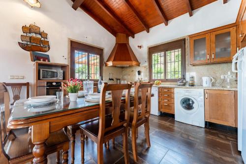 a kitchen with a large wooden table and chairs at MalagaSuite Villa Rural Madeira in Algarrobo