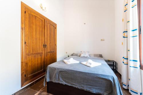 a bedroom with a bed with two towels on it at MalagaSuite Villa Rural Madeira in Algarrobo
