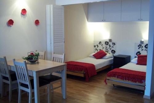 a room with two beds and a table and a dining room at Edelweiss Residenza Quadra in Flims