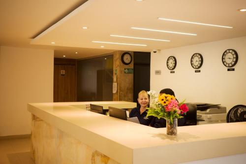 two women sitting in an office with a reception desk at Hotel La Riviera in Santa Marta