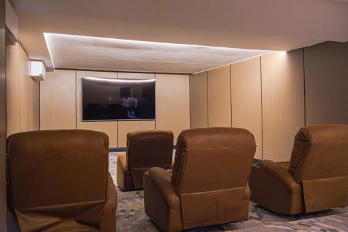Una sala de espera con sillas y un televisor de pantalla plana. en Daif Inn Serviced Apartments - Al Naseem, en Riad