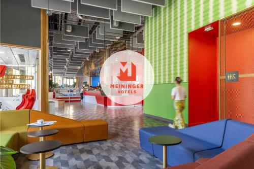 a lobby with a m member industries sign and stools at MEININGER Hotel Paris Porte de Vincennes in Paris
