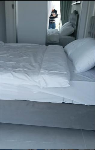 a bed with white sheets and pillows in a room at Bedroom flat Caesar resort, Iskele north Cyprus in Vrysoules