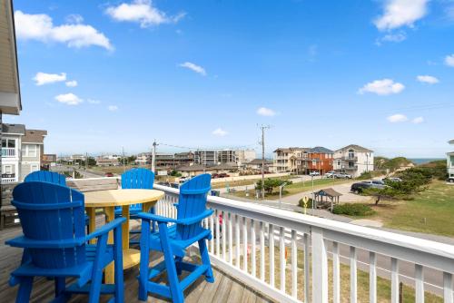 a table and chairs on a balcony with a view of the ocean at Salty Vibes in Nags Head