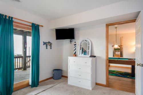a bedroom with a bed and a dresser and a window at Salty Vibes in Nags Head