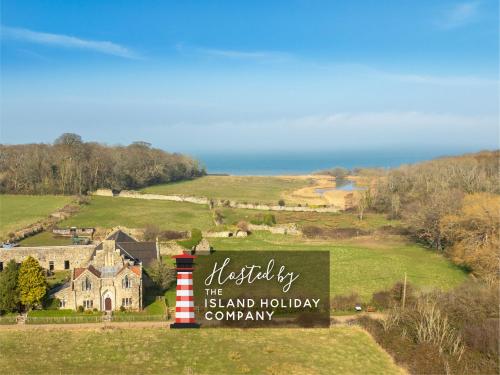 a sign for the island holiday company in front of a house at The Old Abbey Farmhouse - Stay at Quarr Abbey Monastery - Pet-Friendly Farmhouse with History & Countryside Views, surrounded by woodland & nature in Ryde