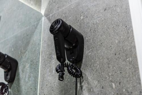 a black hair dryer on the ground at Amel's Rooms in Tirana