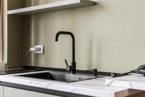 a kitchen sink with a faucet on a counter at Amel's Rooms in Tirana