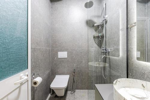 a bathroom with a shower with a toilet and a sink at Amel's Rooms in Tirana