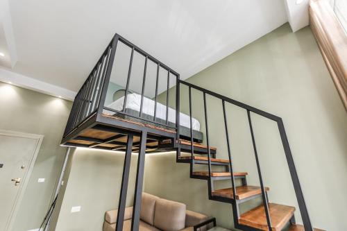 a metal spiral staircase with a bed on it at Amel's Rooms in Tirana