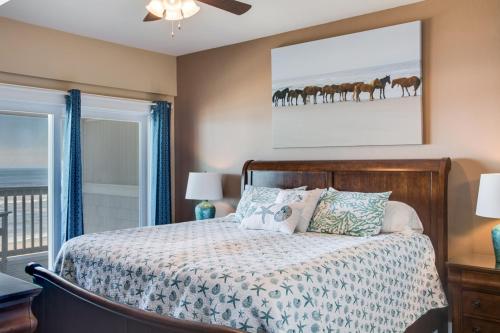 a bedroom with a bed with horses on the wall at Star of the Sea in Kill Devil Hills