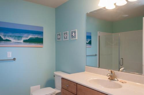 a bathroom with a sink and a toilet and a mirror at Star of the Sea in Kill Devil Hills