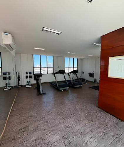 an empty gym with treadmills and a projection screen at Flat em Hotel, Até 4 Hóspedes, Piscina, Garagem , Jr Catito in Brasilia