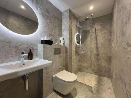a bathroom with a toilet and a sink and a shower at Luise LuXe Suites in Tallinn
