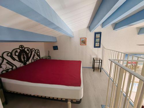 une chambre avec un grand lit avec une couverture rouge dans l'établissement Villa Mitoyenne avec Piscine et Parking Privé, à 15 min de la Plage et Activités Nautiques - FR-1-607-62, au Cap d'Agde