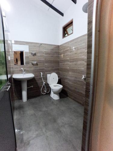 a bathroom with a toilet and a sink at Orient Lodge - Galewela in Beligamuwa