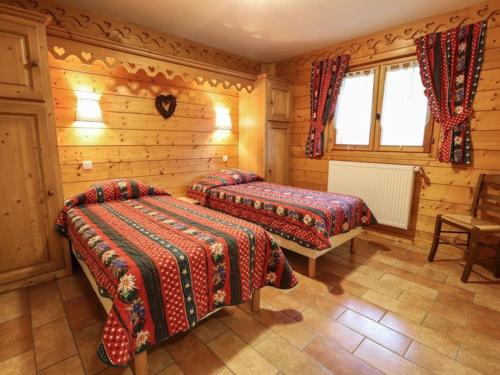two beds in a room with wooden walls at Luxueux chalet 5 pièces pour 10 pers. avec sauna, terrasse, proche des pistes et navettes - FR-1-676-22 in Châtel