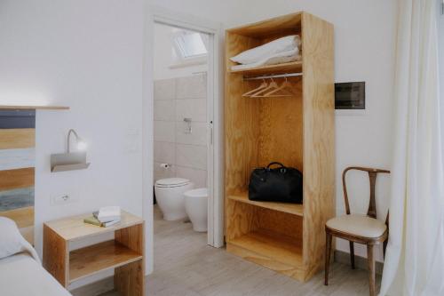 a small room with a bed and a bathroom with a toilet at Le Vie di Feronia in Terracina