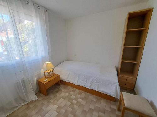 une petite chambre avec un lit et une fenêtre dans l'établissement Appartement T3 RDC avec Terrasse et Climatisation - FR-1-423-325, au Grau-dʼAgde