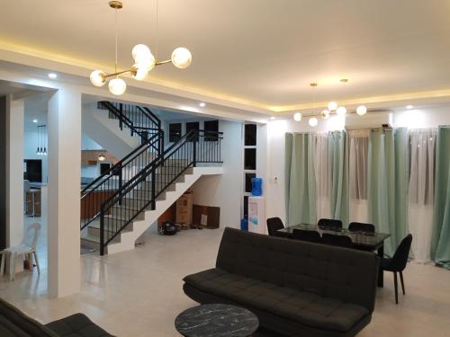 a living room with a couch and a staircase at Oia in Moalboal