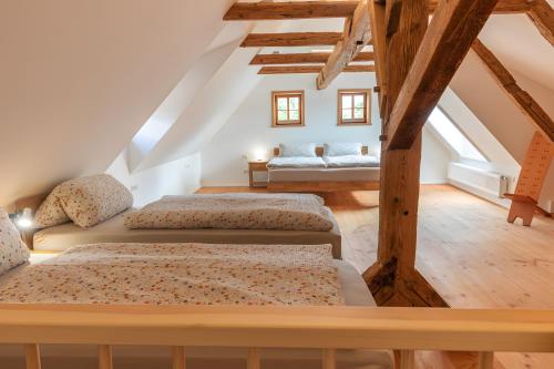 two beds in a attic room with wooden beams at Ferienwohnung Hochwald in Hörnitz