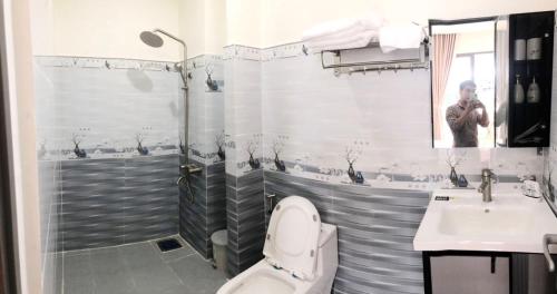 a bathroom with a shower and a toilet and a sink at Thatico Homestay in Kinh Dinh