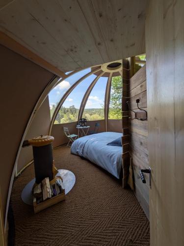 une chambre avec un lit et une grande fenêtre dans l'établissement Les Renardières - Usson en Forez, à Usson-en-Forez